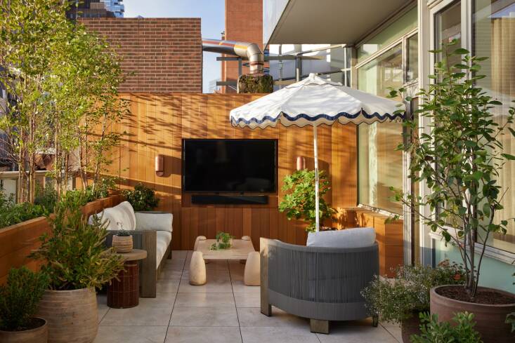 Above: The client had an unusual request: She wanted to be able to watch TV outside, so Osofsky and Bertulli designed a niche in the wall paneling to house the television, sound bar, and wiring.